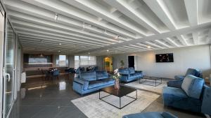salon z niebieskimi kanapami i stołem w obiekcie Tranquillo UpTown Lecce w mieście Lecce