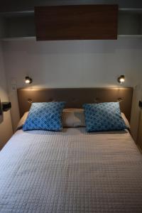 una camera da letto con un letto con cuscini blu di Camping Gabicce Monte a Gabicce Mare