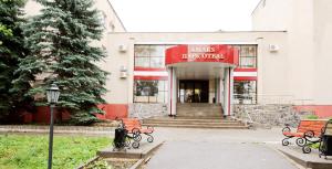 un bâtiment avec bancs devant un magasin dans l'établissement AMAKS Park Hotel, à Tambov