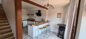 - une cuisine avec un comptoir et des tabourets dans une pièce dans l'établissement Agréable maison en duplex dans un quartier calme, à Perpignan