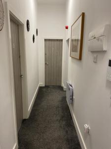 un couloir avec des murs blancs, une porte et une chambre dans l'établissement 2B SPV Double En-suite Room, à Wakefield