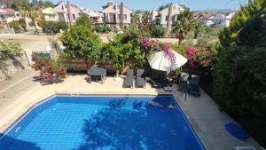 een uitzicht over een zwembad met een parasol bij Villa Ruby in Fethiye