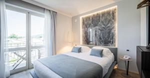 a bedroom with a bed and a large window at Hotel Luna in Marina di Massa