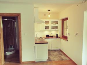 a kitchen with white cabinets and a sink at Zwierzyniec u Kowala in Zwierzyniec