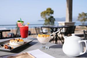 a table with a plate of food and a drink at Margo Beach Hotel in Gythio