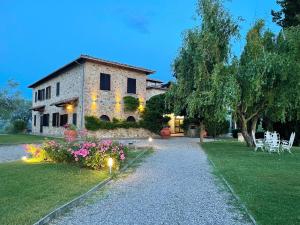 a stone house with lights in the yard at La Loggia - Villa Gloria -Adults Only in Quercegrossa