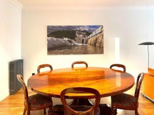uma sala de jantar com uma mesa de madeira e cadeiras em Luxury stay in the heart of the city em San Sebastián