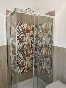 a shower with a glass door with a floral pattern at CasaAle in Anacapri +26 photos