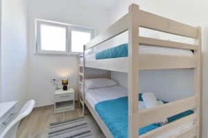 sypialnia z łóżkiem piętrowym, biurkiem i oknem w obiekcie Villa Manuela with heated pool 400 meters from the sea - by TA Leut Agency w mieście Vrsi +37 zdjęć