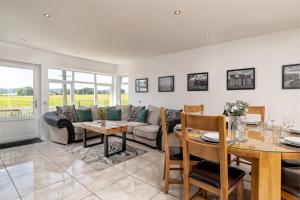 a living room with a couch and a table at Stunning, Remodelled Cottage, Picturesque Location in Duncanston