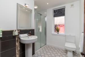 La salle de bains est pourvue d'un lavabo et d'une douche en verre. dans l'établissement Stunning, Remodelled Cottage, Picturesque Location, à Duncanston
