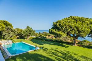 an image of a swimming pool in a yard with the ocean at Vila Santa Eulália in Albufeira