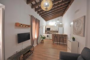 sala de estar con TV y cocina en Original Céntrico Bohemio, en Jerez de la Frontera