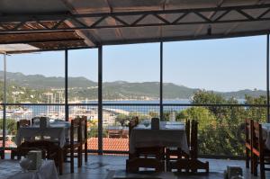 a restaurant with tables and chairs and a large window at Hotel Nisa in Kas