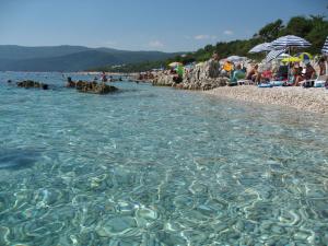 a group of people on a beach with the water at Apartments Zdenka in Labin