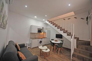 een woonkamer met een bank, een keuken en een trap bij Palacete Centro estilo Luxe in Jerez de la Frontera