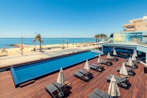 un complexe avec une piscine et une plage dans l'établissement Dom Jose Beach Hotel (Plus), à Quarteira