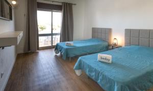 a hotel room with two beds and a window at Apartamentos Pedro for Families by Bedzy in Albufeira