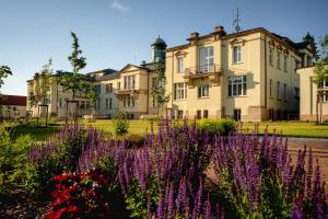 a building with purple flowers in front of it at Hotel Zámeček in Poděbrady