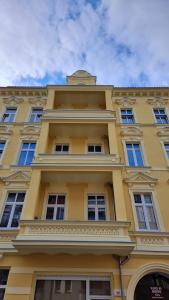 a tall yellow building with windows on the side of it at Kamienica1899 in Szczecin