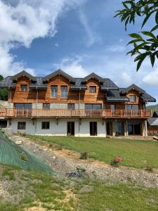 uma grande casa de madeira com um telhado de gambrel em SKI LODGE em La Toussuire