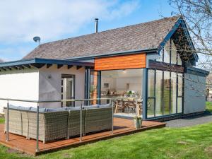 a home with a large glass extension with a deck at Lambs Lodge in Bamburgh