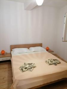 a bedroom with a bed with two pillows on it at Apartmani Gajeta in Biograd na Moru