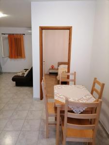 uma sala de jantar com uma mesa e um sofá em Apartmani Gajeta em Biograd na Moru