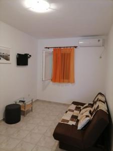 uma sala de estar com um sofá e uma janela em Apartmani Gajeta em Biograd na Moru