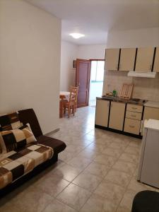 uma sala de estar com um sofá e uma cozinha em Apartmani Gajeta em Biograd na Moru
