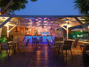 a restaurant with tables and chairs on a deck at night at Calypso Hotel in Matala