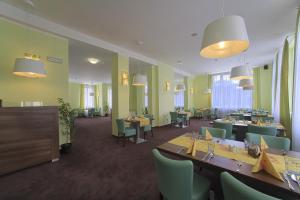 a restaurant with green walls and tables and chairs at Hotel Zámeček in Poděbrady