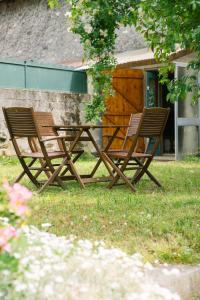 2 sillas de madera y una mesa en un patio en Gite Tilia, en Huos
