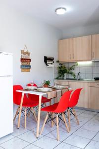 a kitchen with a table and four red chairs at Lydia's House in Kavála