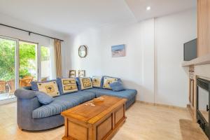 a living room with a blue couch and a table at Lago y Playa in Port d'Alcudia