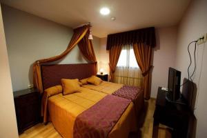 a bedroom with a bed and a television in it at Posada Real La Yensula in El Puente