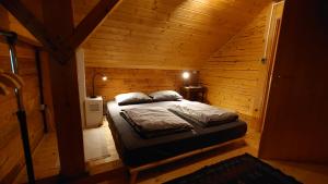 a bedroom with a bed in a wooden cabin at ARKA in Belavići
