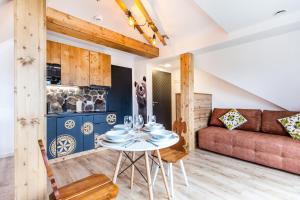 a living room with a table and a couch at Apartamenty na Leśnej in Bukowina Tatrzańska