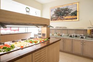 a kitchen with many plates of food on a counter at Calypso Hotel in Matala