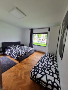 two beds in a room with a window at The White Villa in Blankenberge