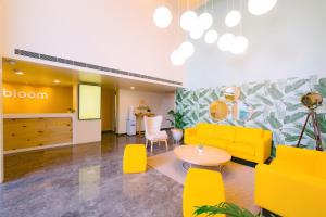 a living room with a yellow couch and a table at Bloom Hotel - Indiranagar in Bangalore