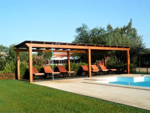 ein Holzpavillon mit Stühlen und einem Pool in der Unterkunft Verdemar in Cercal