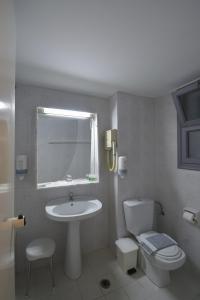 a bathroom with a white sink and a toilet at OLYMPOS BEACH HOTEL in Faliraki
