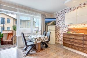 a dining room with a table and chairs and a kitchen at Ferienwohnungen zum Ostseestrand in Ahlbeck