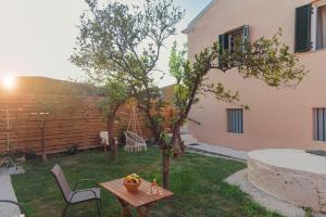 a small yard with a table and a tree at Archontiko ''Danae'' in Lefkimmi
