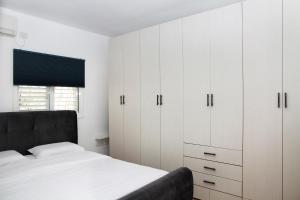 a bedroom with white cabinets and a bed at Apartments4you Betti in Bat Yam
