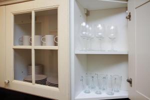 a cabinet filled with wine glasses and plates at Apartments4you Betti in Bat Yam +34 photos