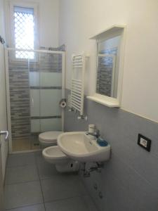 a bathroom with a sink and a toilet and a mirror at Hotel Abamar in Rimini