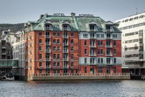 ベルゲンにあるクラリオン ホテル アドミラルの水の横の大きな赤い建物