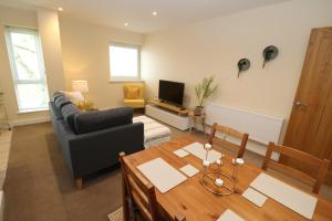 a living room with a table and a couch and a television at The Retreat - IH21ALL - APARTMENT 6 in Thornaby on Tees